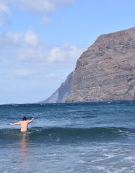 A person wading into the waves in the playa de los guios beach